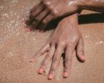 main bronzées sable mer